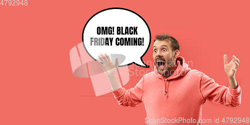 Image of Half-length close up portrait of young man on coral background with black friday lettering