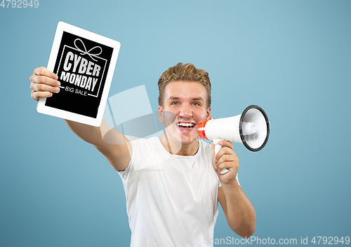 Image of Portrait of young man showing tablet screen, black friday