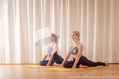 Image of two women doing yoga at home