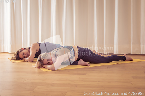 Image of two women doing yoga at home