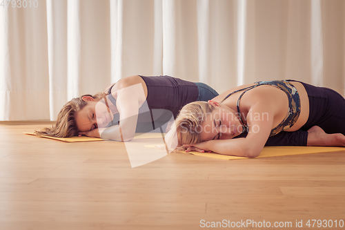 Image of two women doing yoga at home