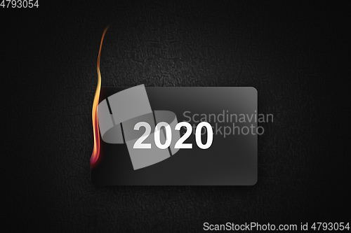Image of burning credit card 2020 on black background