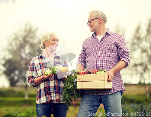 Image of senior couple with box of vegetables on farm