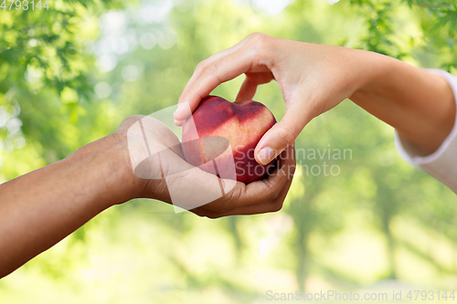 Image of multiracial couple hands with peach over green