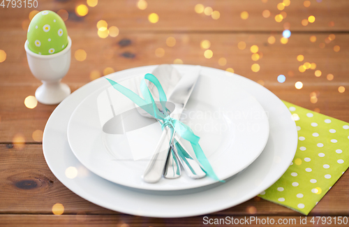 Image of easter egg in cup holder, plates and cutlery