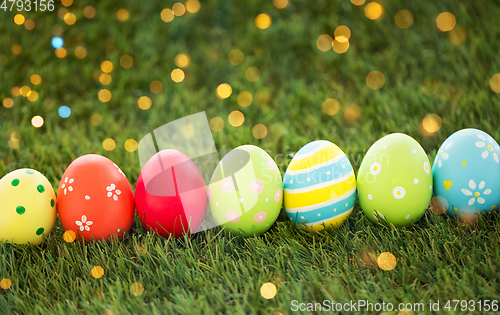 Image of row of colored easter eggs on artificial grass