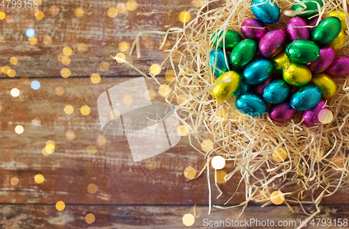 Image of chocolate eggs in foil wrappers in straw nest