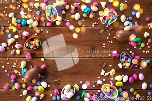 Image of chocolate eggs and candy drops on wooden table