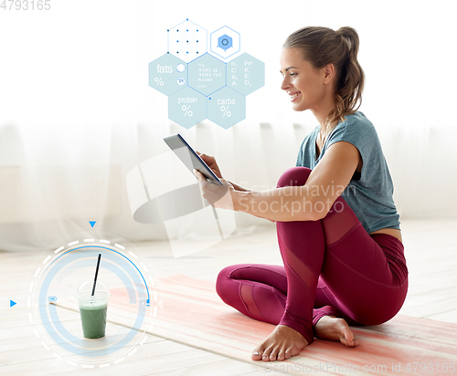 Image of woman with tablet pc and drink at yoga studio