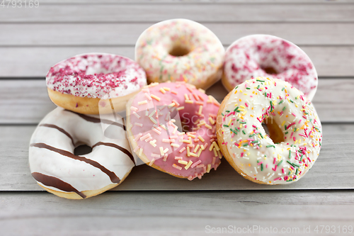 Image of close up of glazed donuts on wooden boards