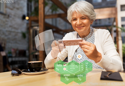 Image of old woman with smartphone and food at restaurant