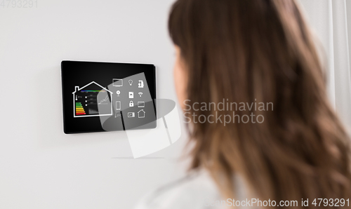 Image of woman looking at tablet computer at smart home