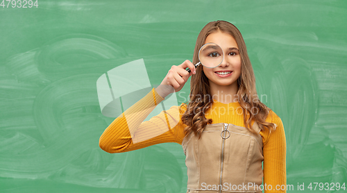 Image of student girl looking through magnifier at school