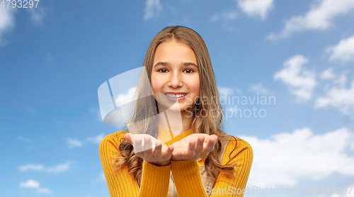 Image of teenage girl holding something on empty hands