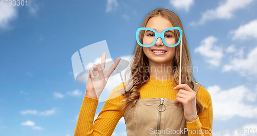 Image of smiling teenage girl with big glasses over sky