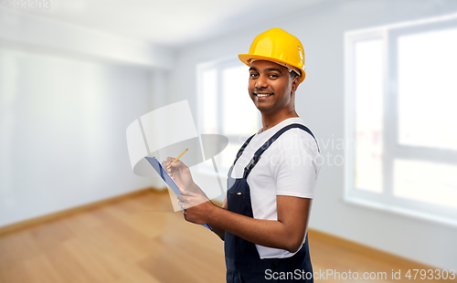 Image of happy builder in helmet with clipboard and pencil