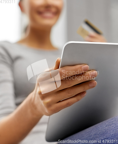 Image of woman with tablet pc and credit card at home