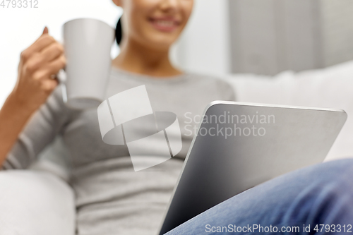 Image of close up of woman with tablet pc computer at home