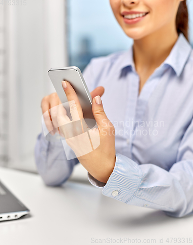 Image of businesswoman with smartphone at office