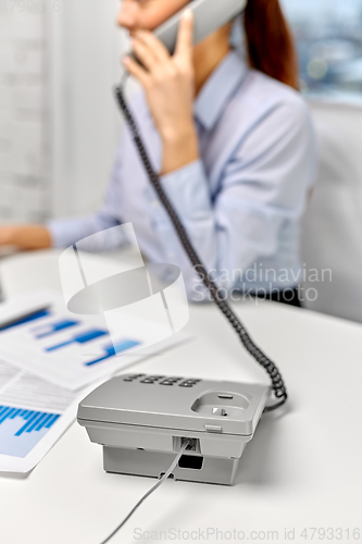 Image of businesswoman calling on desk phone at office