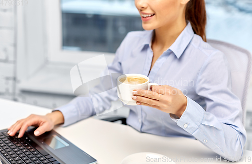 Image of businesswoman with coffee and laptop at office