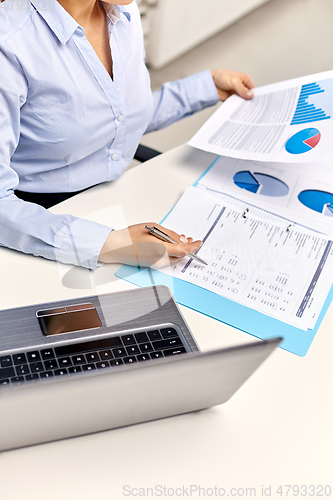 Image of businesswoman with papers working at office