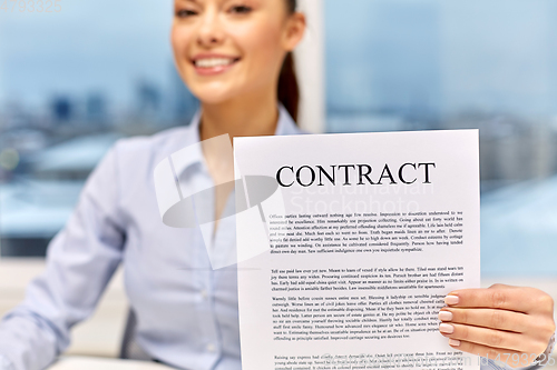 Image of happy businesswoman holding contract at office