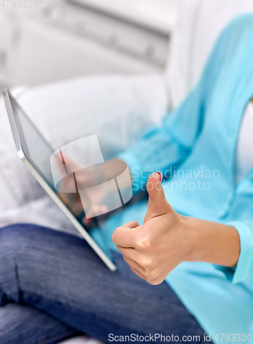 Image of close up of woman with tablet pc showing thumbs up