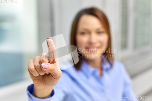 Image of businesswoman touching something with finger