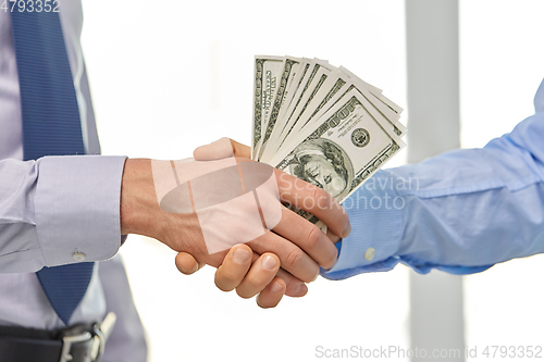 Image of close up of businessmen's hands holding money