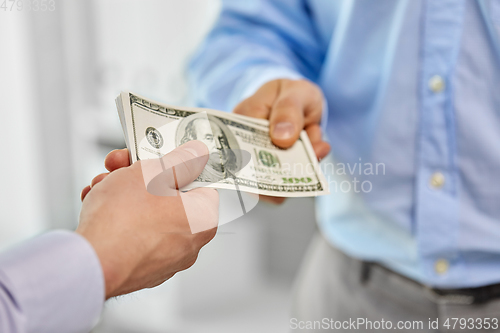 Image of close up of businessmen's hands holding money