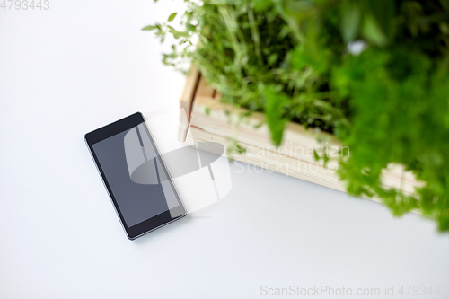 Image of smartphone with herbs and flowers in box