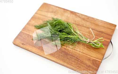 Image of bunch of dill on wooden cutting board