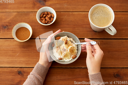 Image of hands with oatmeal breakfast and cup of coffee