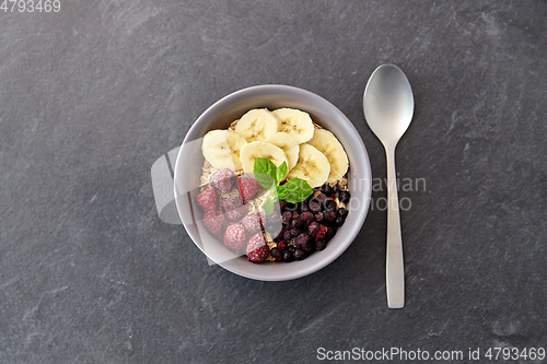 Image of oatmeal breakfast with berries, banana and spoon