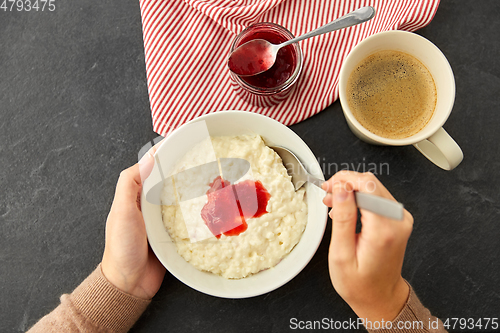 Image of hands with porridge breakfast and cup of coffee