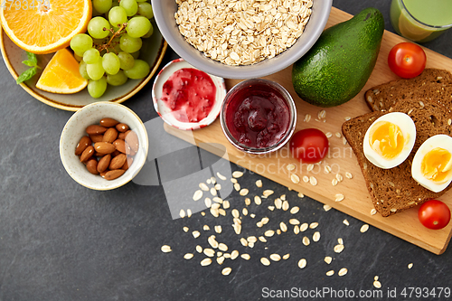 Image of oatmeal, fruits, toast bread, egg, jam and milk