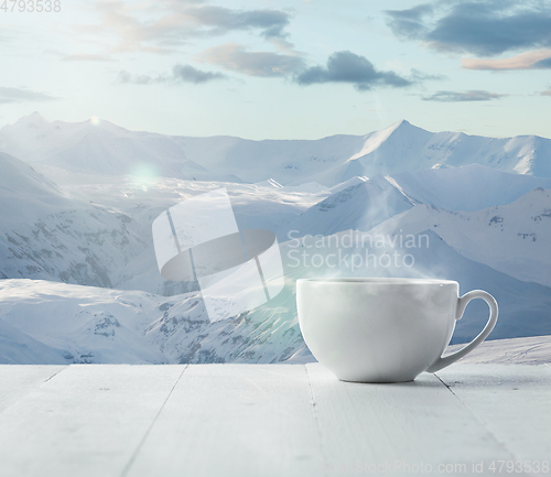 Image of Single tea or coffee cup and landscape of mountains on background