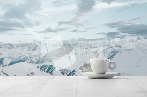 Image of Single tea or coffee cup and landscape of mountains on background