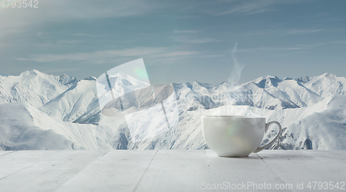 Image of Single tea or coffee cup and landscape of mountains on background