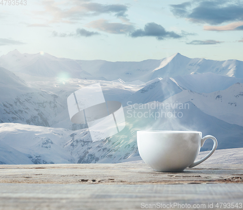 Image of Single tea or coffee cup and landscape of mountains on background