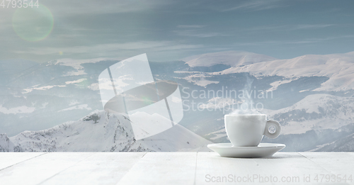 Image of Single tea or coffee cup and landscape of mountains on background