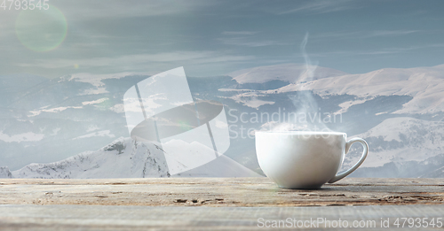 Image of Single tea or coffee cup and landscape of mountains on background