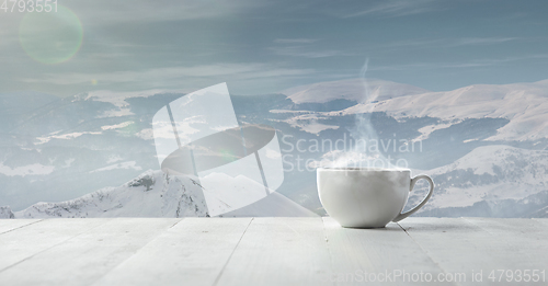 Image of Single tea or coffee cup and landscape of mountains on background