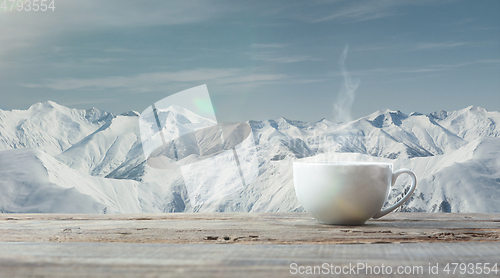 Image of Single tea or coffee cup and landscape of mountains on background