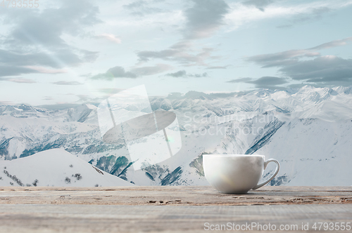 Image of Single tea or coffee cup and landscape of mountains on background