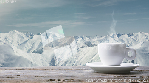 Image of Single tea or coffee cup and landscape of mountains on background