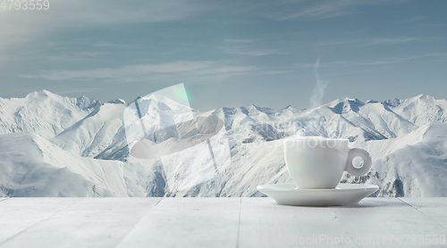 Image of Single tea or coffee cup and landscape of mountains on background