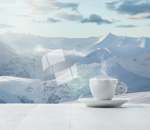 Image of Single tea or coffee cup and landscape of mountains on background