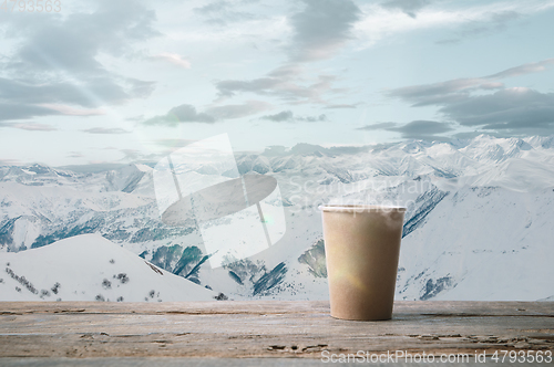 Image of Single tea or coffee mug and landscape of mountains on background